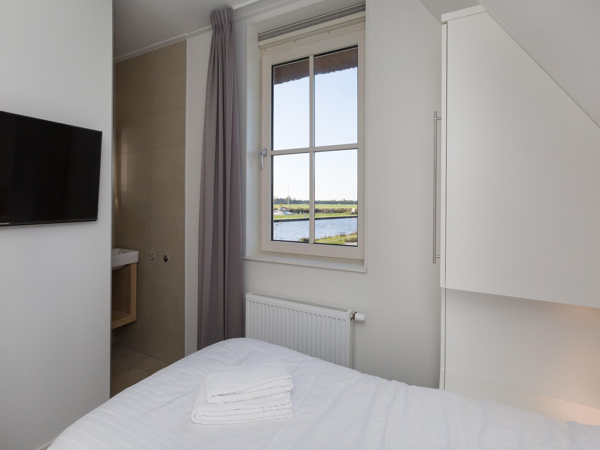 Een slaapkamer van Friese Meren Villa's 18 in Delfstrahuizen