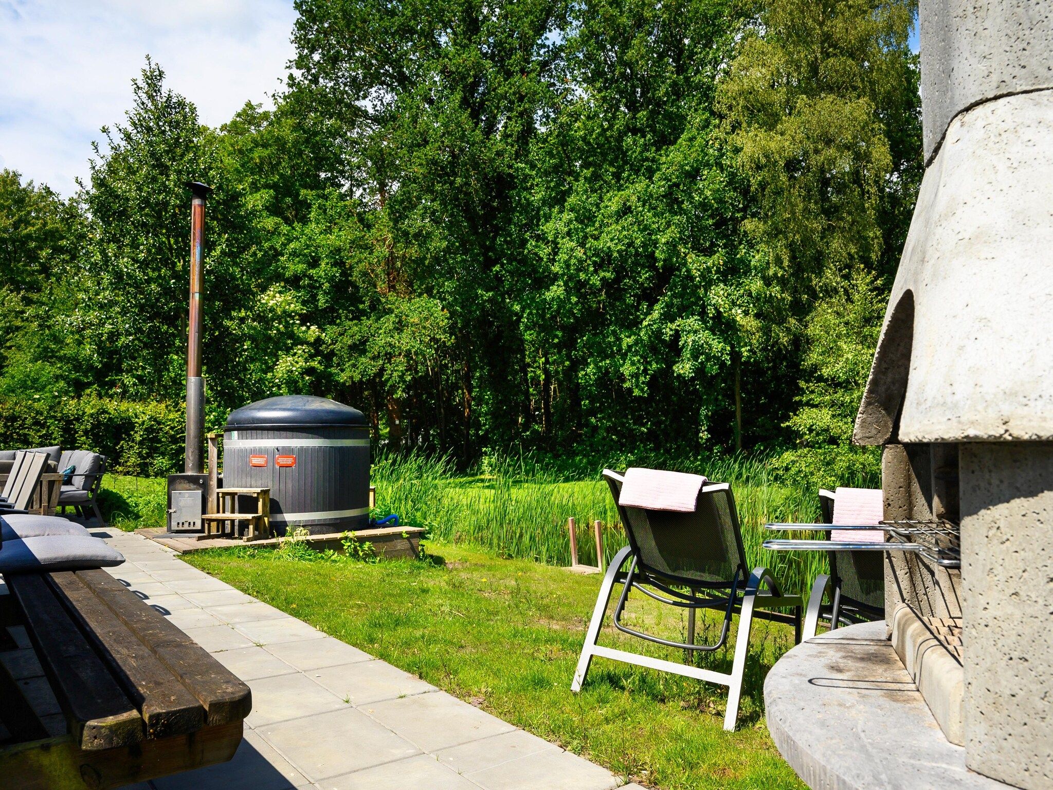 De tuin van 18 pers Ellersinghuis wellness met houtgestookte hottub in Vlagtwedde