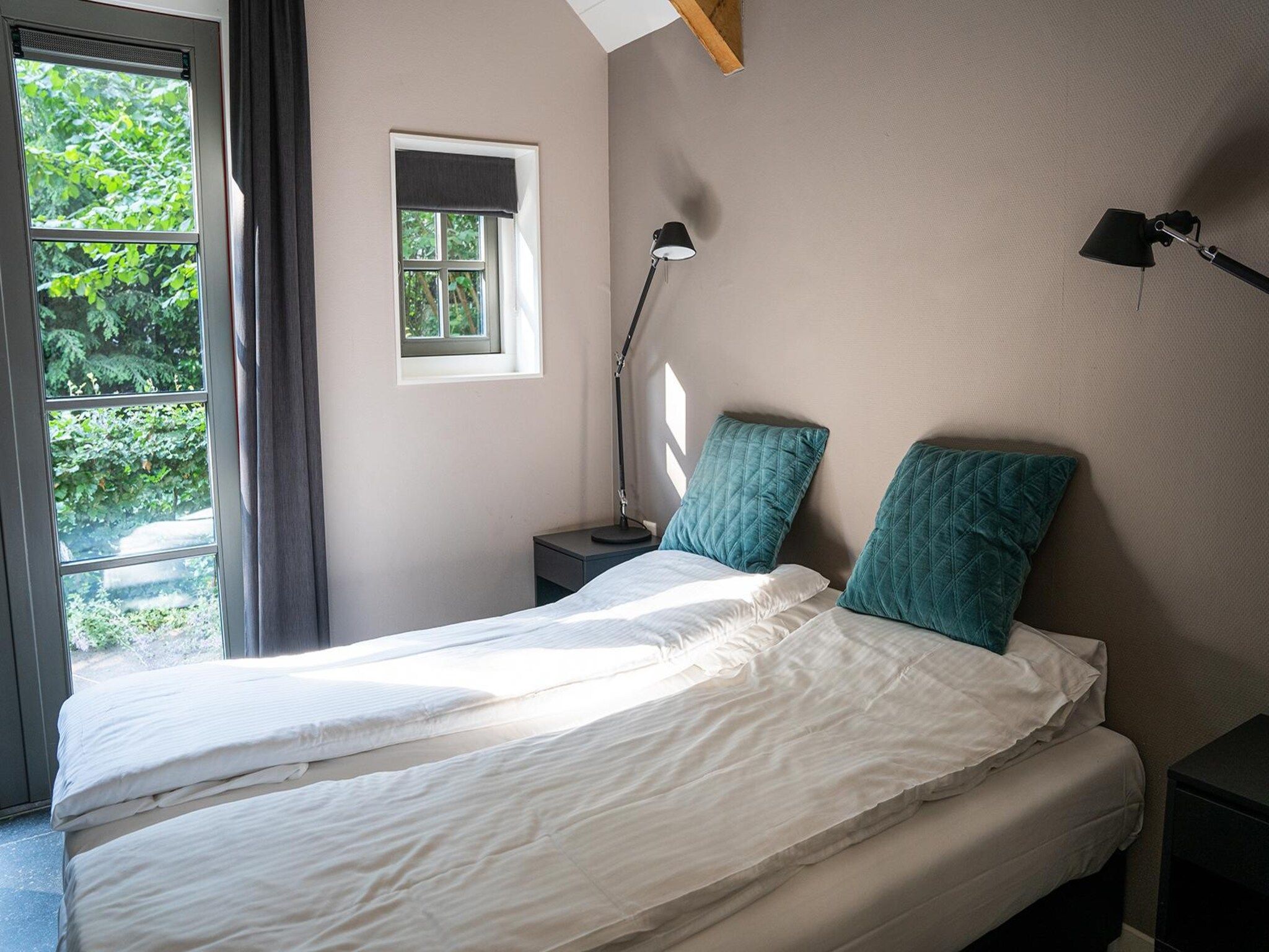 Een slaapkamer van Vlindervallei Boshuis 16p in Ermelo