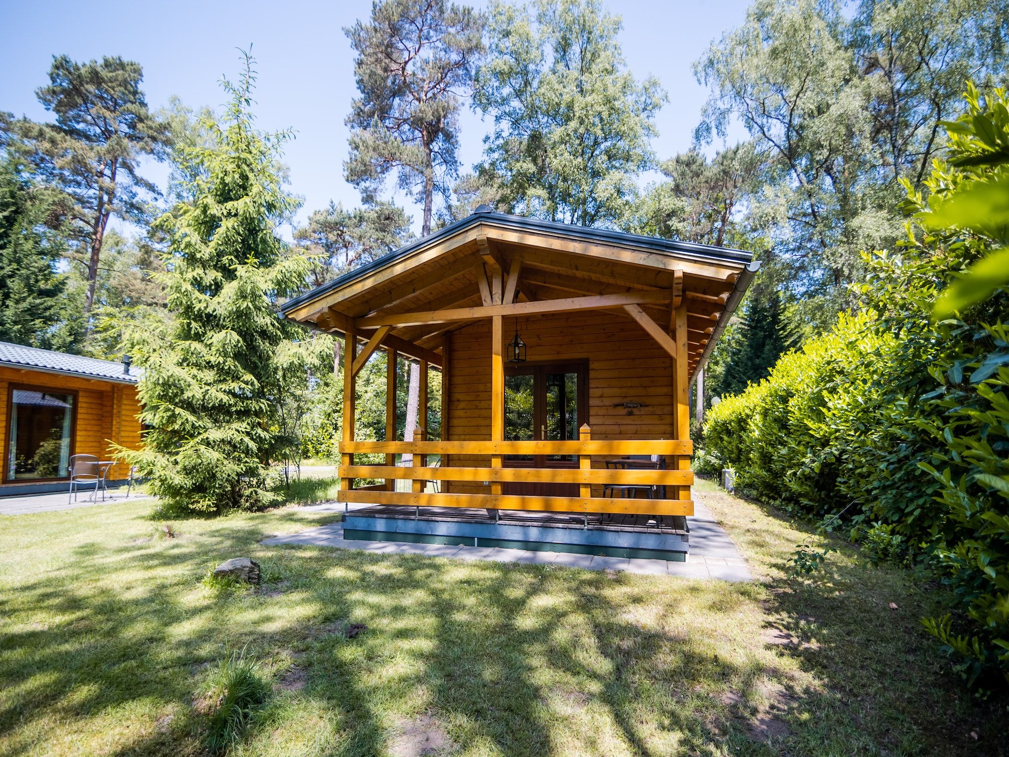 De tuin van 2-persoons wellness lodge in Markelo