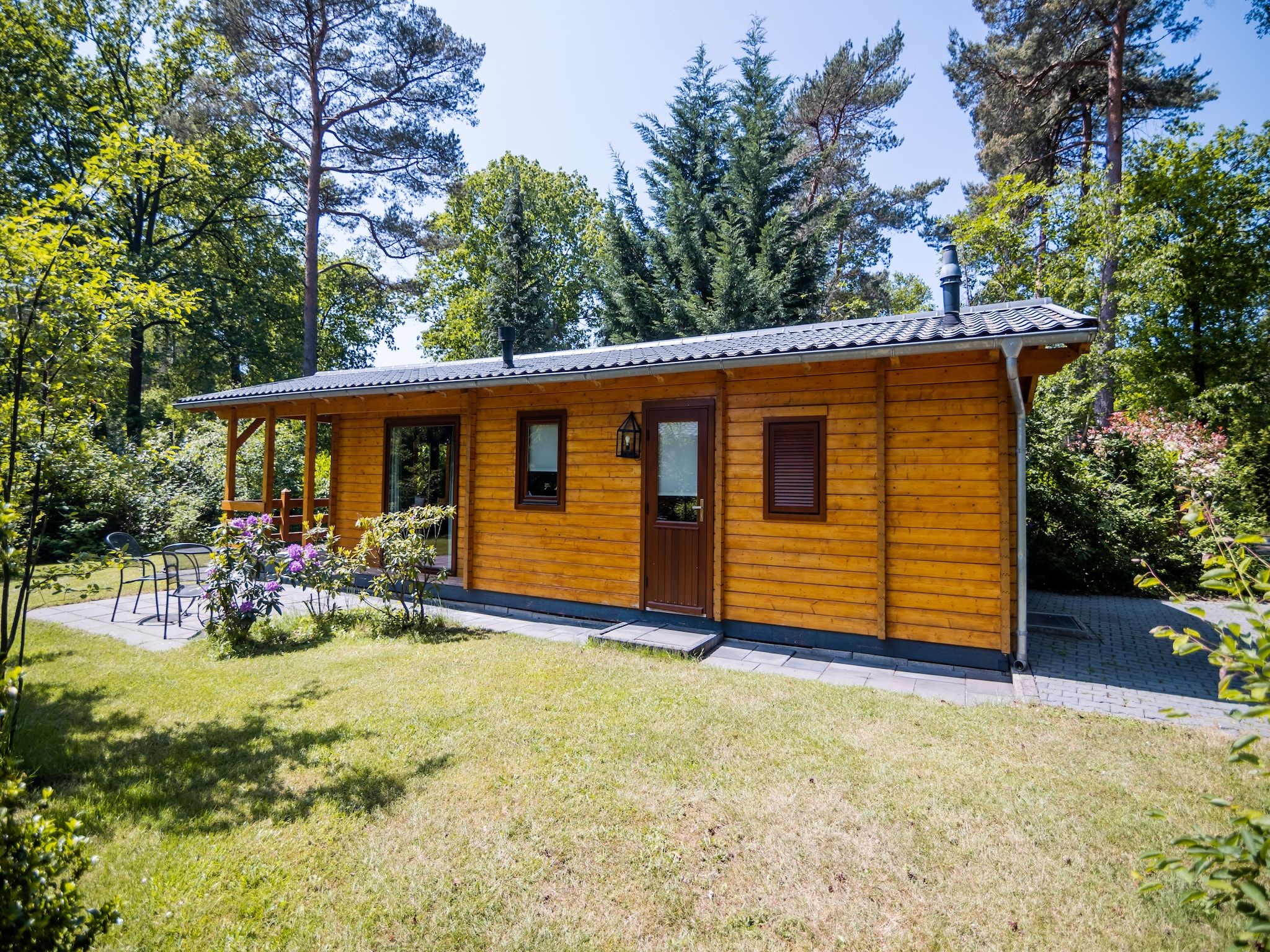 De tuin van 2-persoons wellness lodge in Markelo