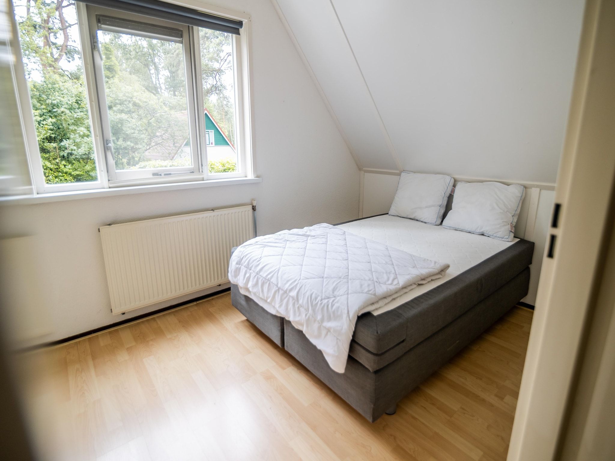 Een slaapkamer van 4-persoons stenen bosvilla in Markelo