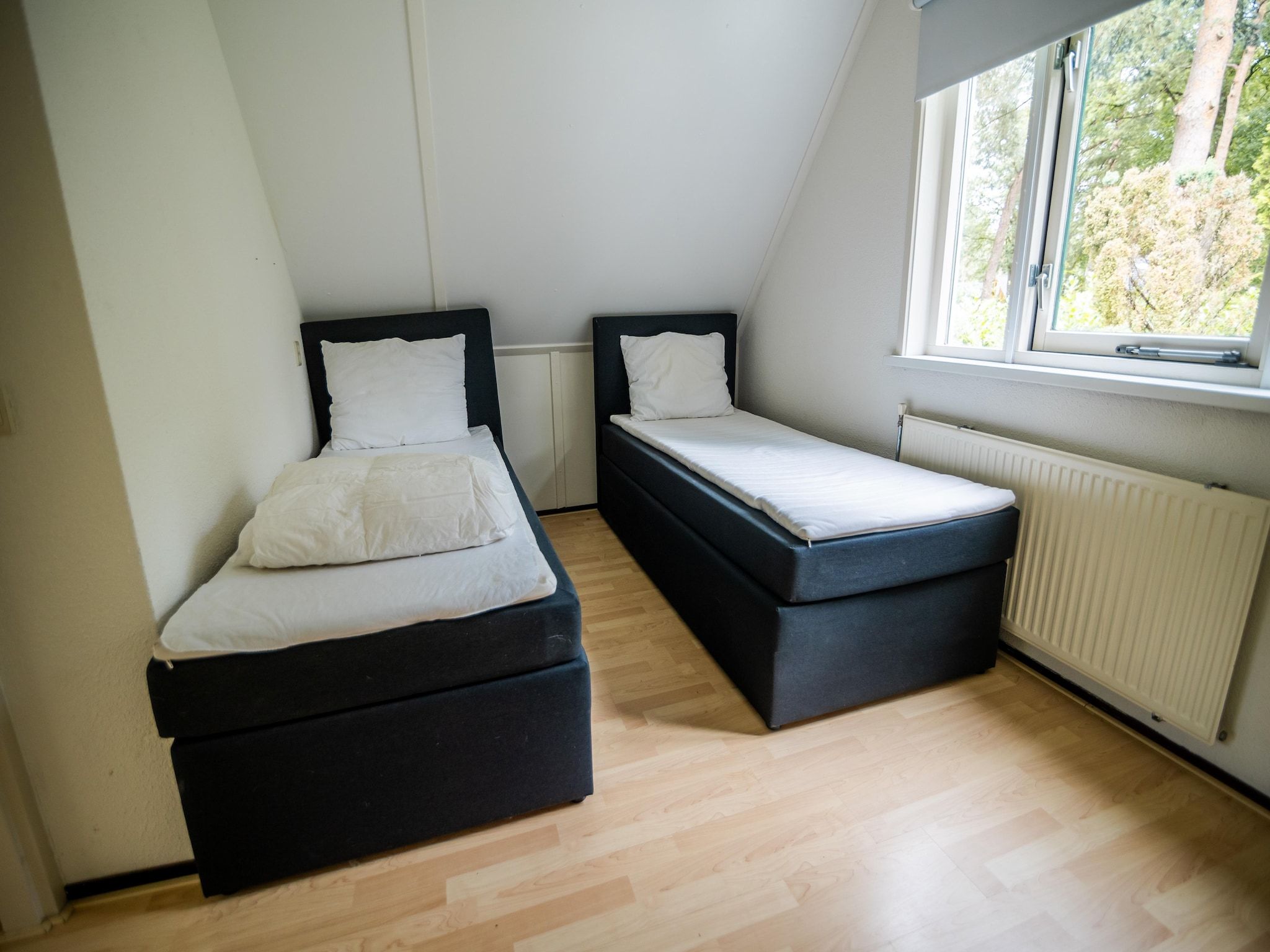 Een slaapkamer van 4-persoons stenen bosvilla in Markelo