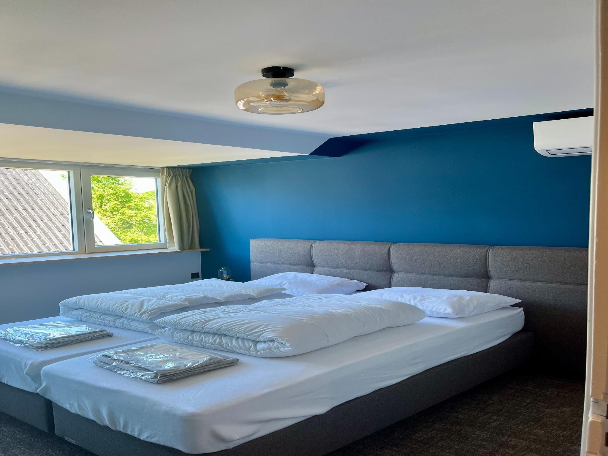 Een slaapkamer van Groepsaccommodatie met 10 luxe tweepersoons kamers in Scherpenzeel (FR)