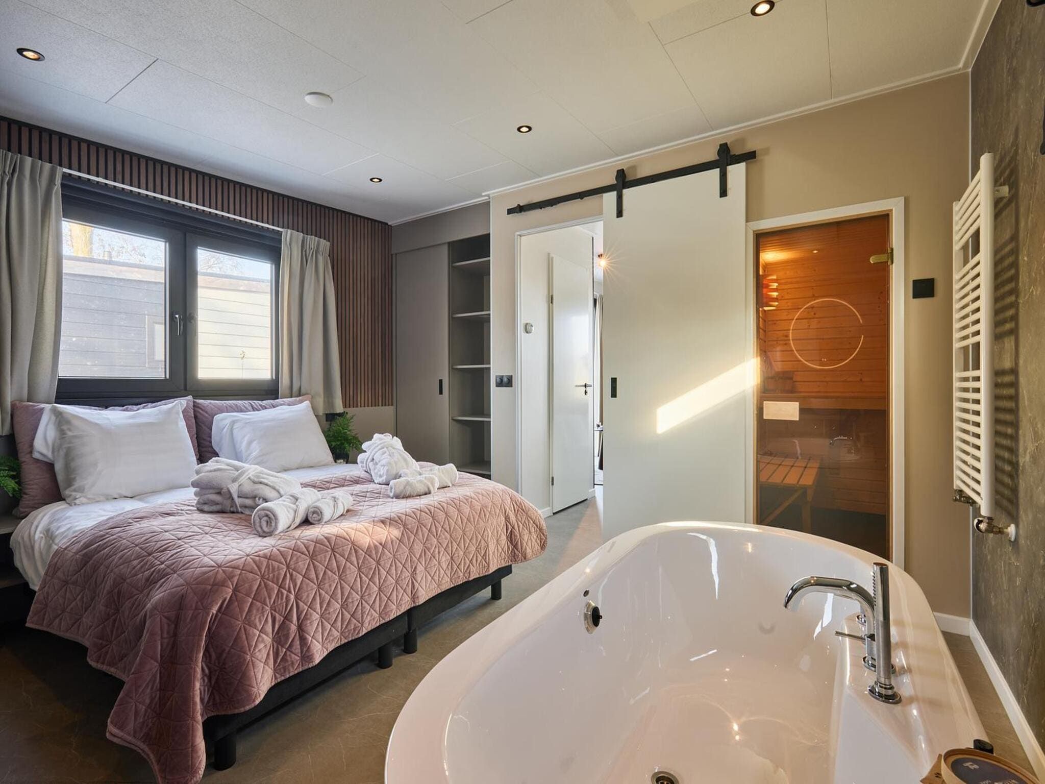 Een slaapkamer van River Lodge 'Wellnesshuus' with whirlpool, sauna, bathtub, and sun shower | 2 people in Zuna