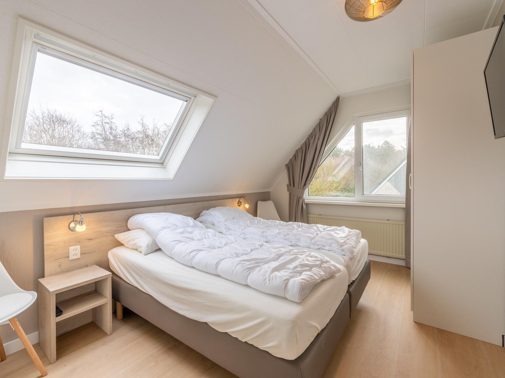 Een slaapkamer van Kamperfoelie 77 in De Koog