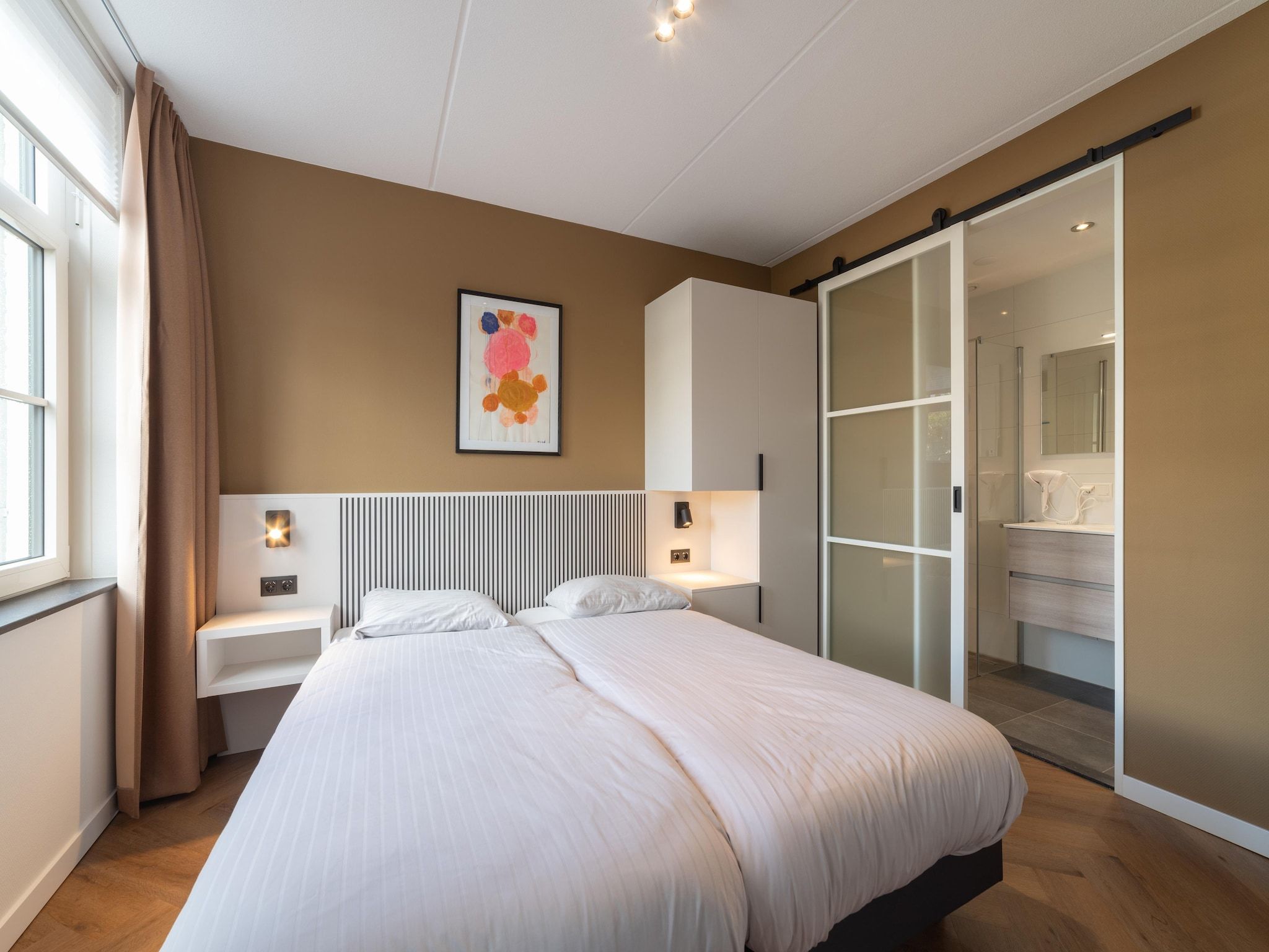 Een slaapkamer van Villa 10 - 12-persoons villa met buitenjacuzzi in Colijnsplaat