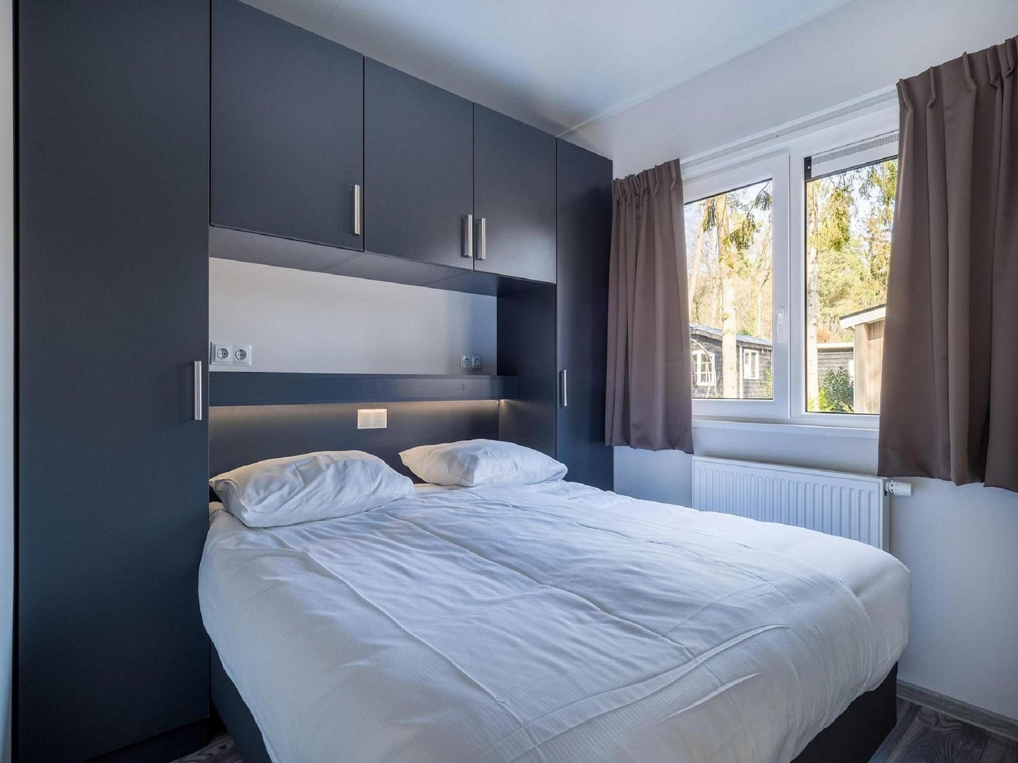 Een slaapkamer van Vakantiepark De Rimboe & De Woeste Hoogte 24 in Hoenderloo