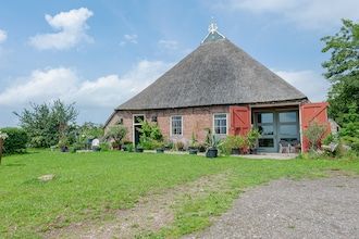 Boerderij aan de Lauwers met roeiboot in Burum