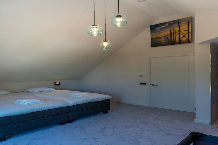 Een slaapkamer van De Grauwe Kiekendief Wellness in Den Burg